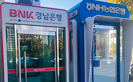창원실내수영장 외부에 위치한 BNK경남은행과 NH농협은행의 현금인출기를 정면에서 촬영하여 이용객을 위한 편의시설 모습을 담은 사진입니다
