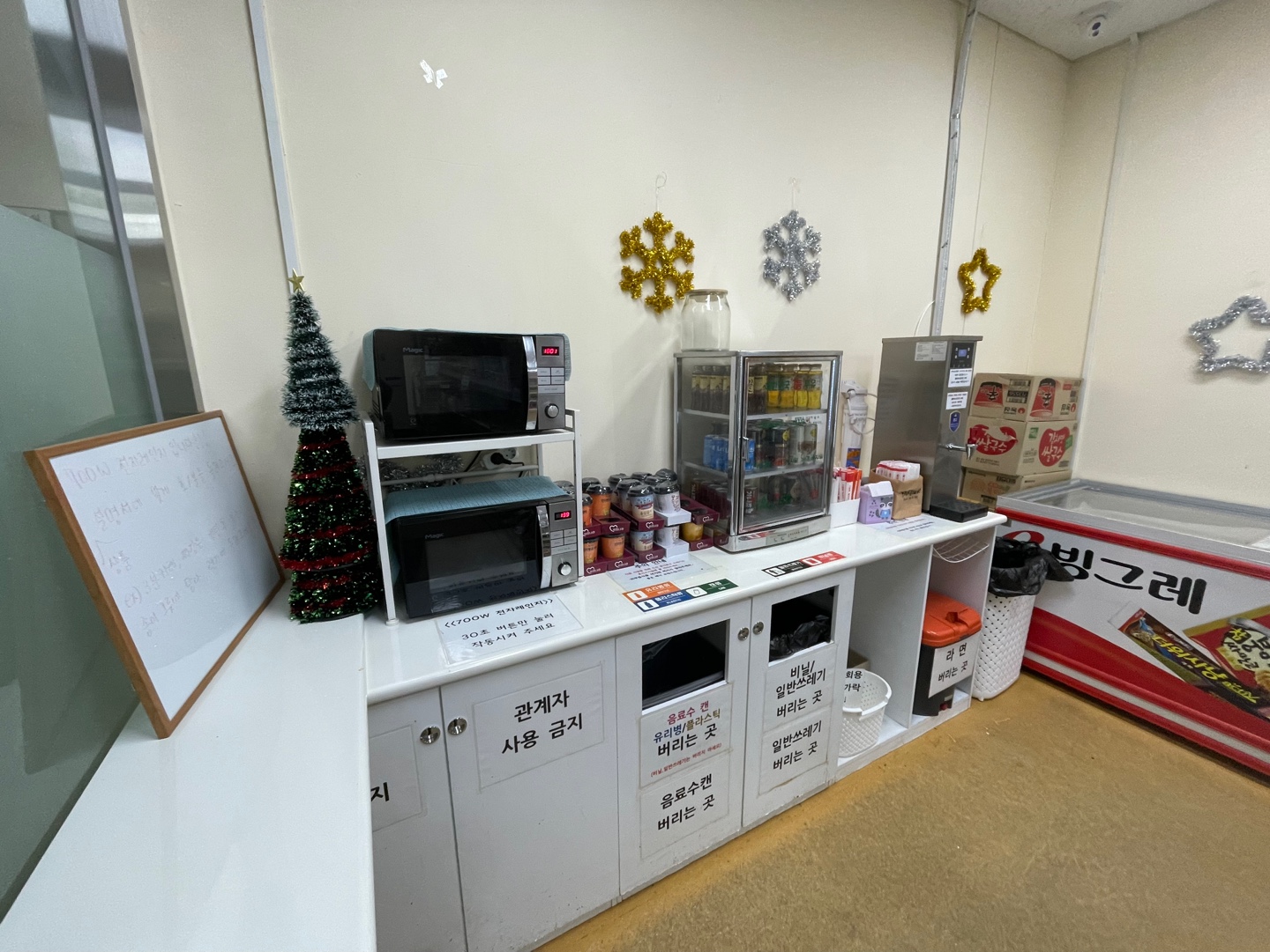 성산스포츠센터 내 지하2층 무인 매점 내부에서 촬영한 사진이며, 음식조리를 위한 전자레인지 및 음료 온장고가 비치되어 있는 사진입니다.