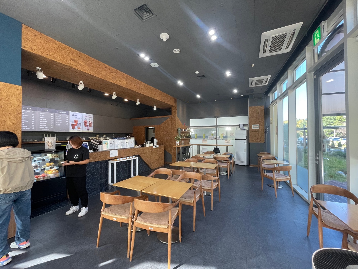 성산스포츠센터 내 카페(COFFEE 702) 내부 사진입니다. 4인용, 2인용 테이블과 좌석이 있습니다.