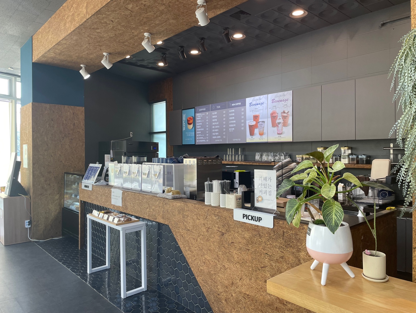 성산스포츠센터 내 카페(COFFEE 702) 계산 및 픽업대 사진입니다. 커피, 음료, 쿠키 등을 판매하고 있습니다.
