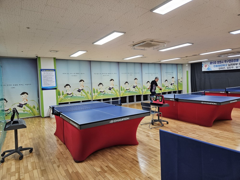진동종합복지관 본관 2층 탁구장 전체적인 모습 촬영이며 탁구대 2대 및 회원들이 탁구를 치고 있는 모습입니다.
