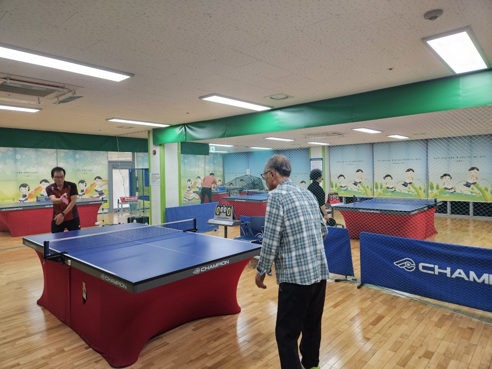진동종합복지관 본관 2층 탁구장 전체적인 모습 촬영이며 회원들이 탁구를 치고 있는 모습입니다.