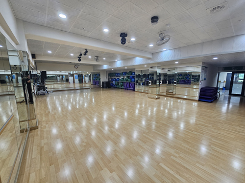 진해국민체육센터의 3층 다목적실 내부이며 좌측 안쪽 가장자리에서 촬영한 사진이며, 넓은 공간을 제공하고 있습니다. 입구를 기준으로 우측에는 프로그램 운영을 위한 짐볼 등 필라테스 도구가 비치되어 있습니다.