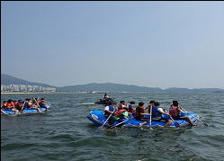 진해 앞바다에서 래프팅을 체험하고 있는 사진으로 동시에 많은 인원이 체험 가능하여 상호 협동심을 기를 수 있는 해양레포츠입니다.